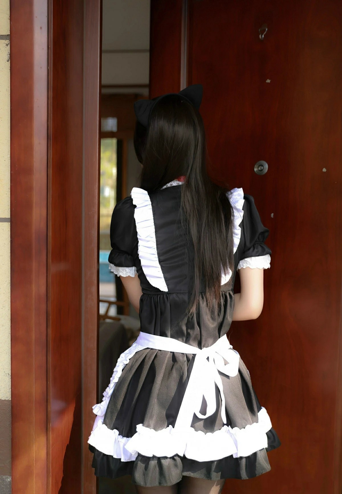 猫耳女仆装少女站在木门旁的背影