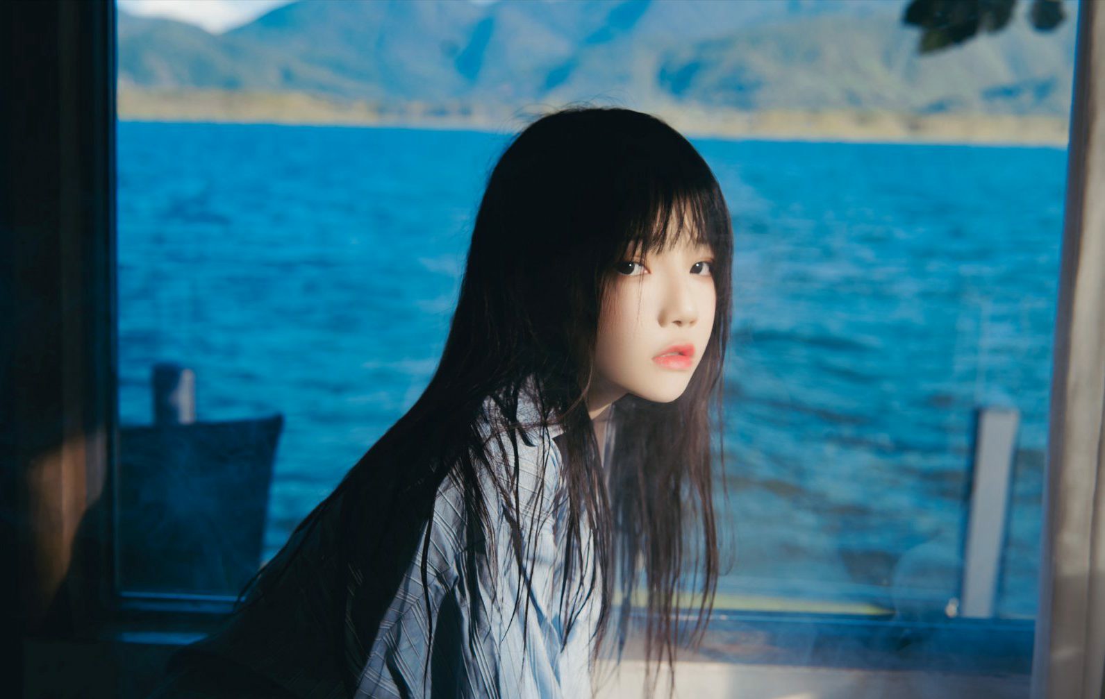窗边湖光山色中的清新少女